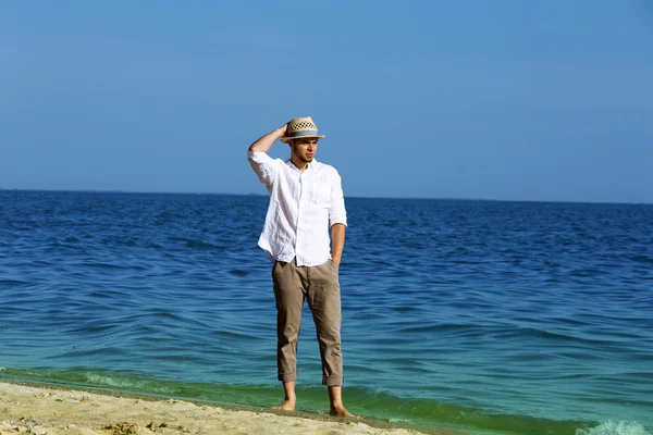 Hombre joven caminando en la playa —  Fotos de Stock