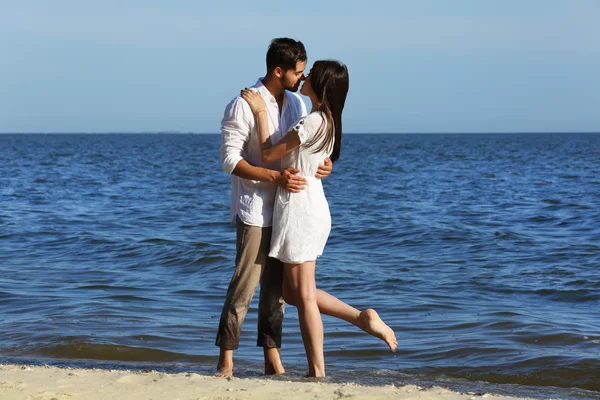 Jeune couple étreignant sur la plage — Photo