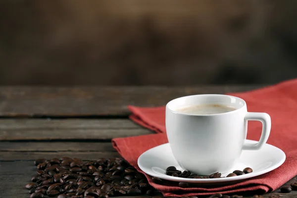 Tazza di caffè e fagioli su sfondo sfocato — Foto Stock