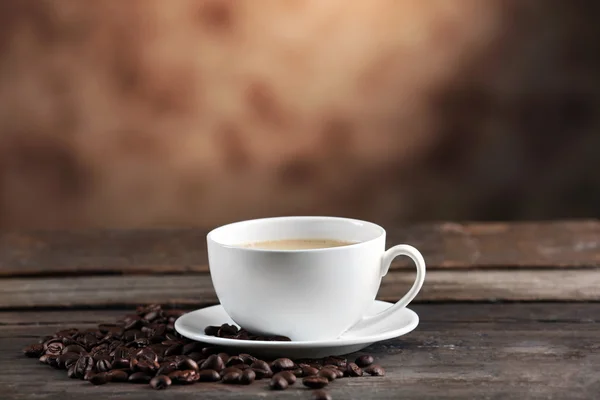 Cangkir kopi dan kacang dengan latar belakang kabur — Stok Foto