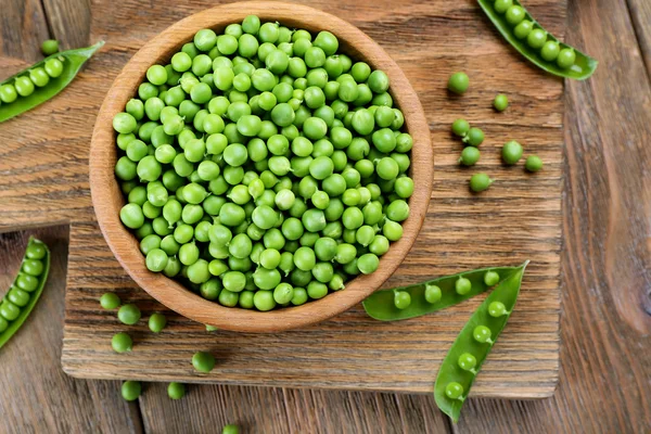 Frische grüne Erbsen in Schüssel auf dem Tisch aus nächster Nähe — Stockfoto