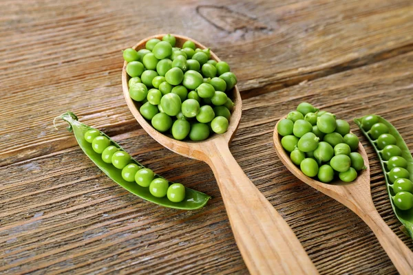 Frische grüne Erbsen im Kochlöffel auf dem Tisch aus nächster Nähe — Stockfoto