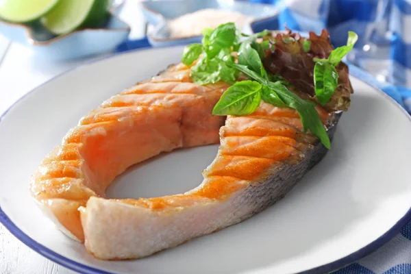 Tasty grilled salmon with greens on table close up — Stock Photo, Image