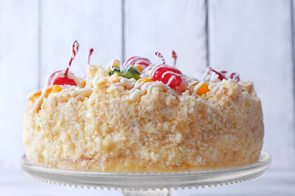 Pastel de mantequilla con cerezas en el soporte, sobre fondo de madera de color —  Fotos de Stock