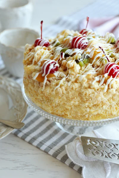 Butter cake with cherries on stand and table setting, on light background — Stock Photo, Image