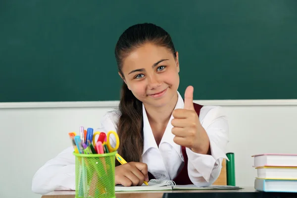 Bela colegial em sala de aula perto de quadro negro — Fotografia de Stock