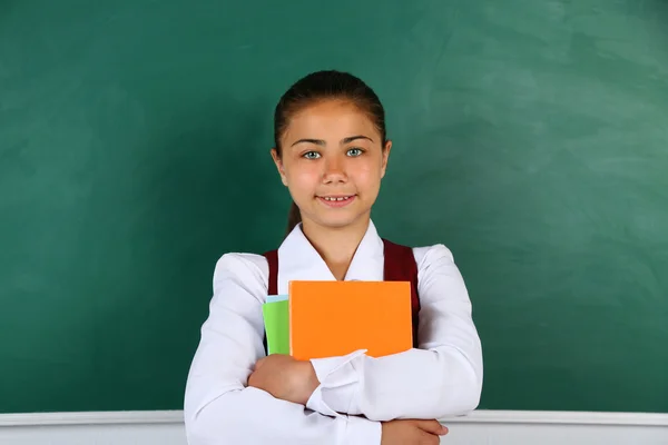 教室の黒板の近くに立っている美しい少女 — ストック写真