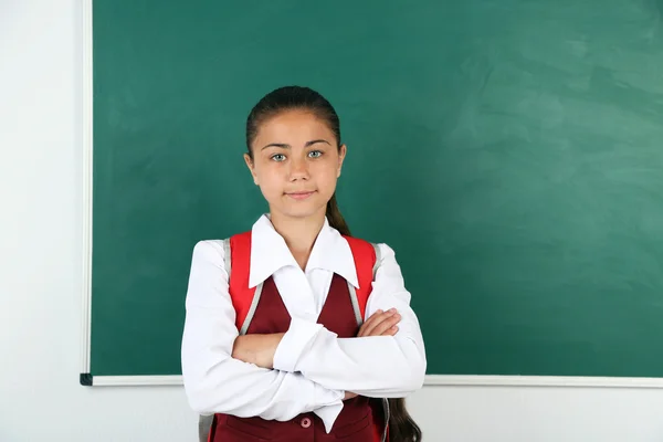 Vacker liten flicka står nära tavlan i klassrummet — Stockfoto