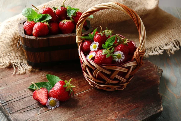 Κόκκινο ώριμες φράουλες σε ψάθινο καλάθι, σε ξύλινο φόντο — Φωτογραφία Αρχείου