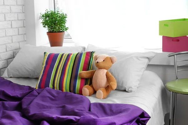 Bequemes Bett mit Teddybär im Schlafzimmer — Stockfoto