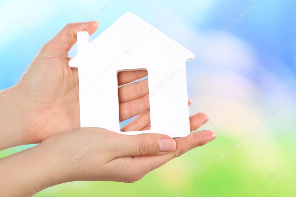 Female hands holding model of house