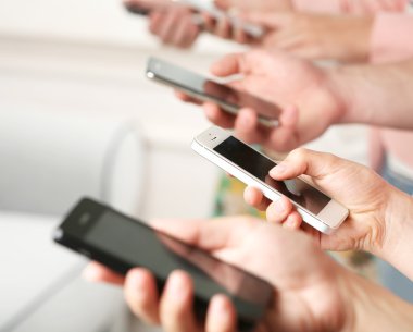 Birçok el cep telefonlarını yakın tutuyor.