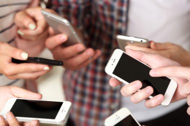 Birçok el cep telefonlarını yakın tutuyor.