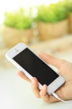 Müzik smartphone içinde el, açık renkli üzerinde