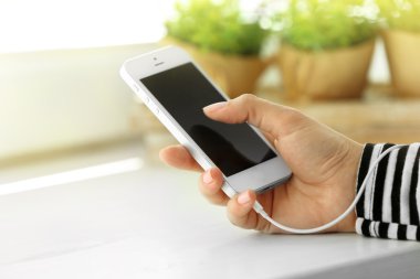 Müzik smartphone içinde el, açık renkli üzerinde