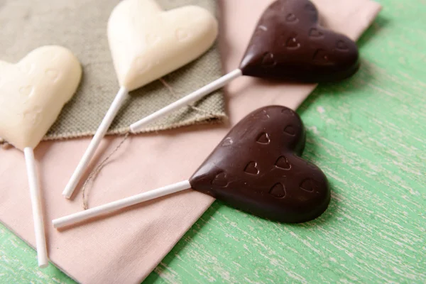 Choklad hjärtformade godis på pinnar på säckväv, närbild — Stockfoto