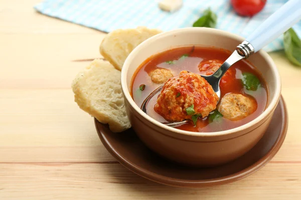 Tomato soup with meat balls on wooden spoon on wooden background — Stock Photo, Image