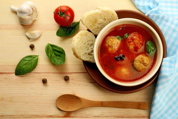 Tomato soup with meat balls on wooden spoon on wooden background — Stock Photo, Image