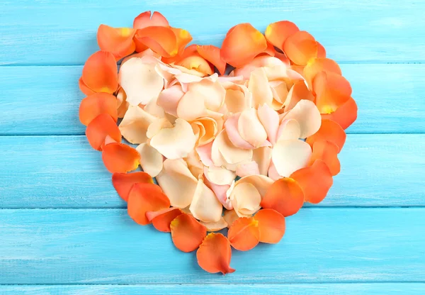 Красивое сердце из лепестков роз на деревянном фоне — стоковое фото