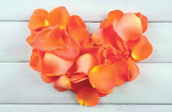 Piękne serce z płatków róż na drewniane tła — Zdjęcie stockowe