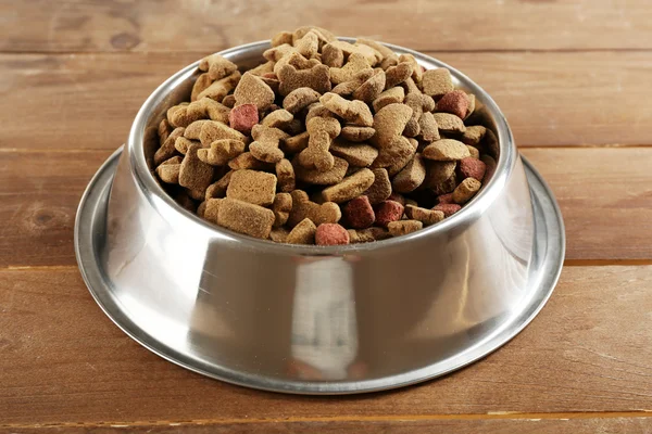 Dog food in bowl on wooden table — Stock Photo, Image