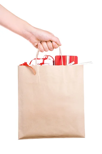 Female hand holding paper bag with present boxes isolated on white — Stock Photo, Image