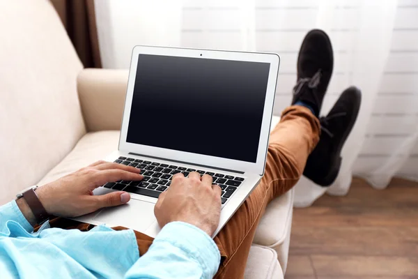 Homme travaillant avec ordinateur portable sur canapé dans la chambre — Photo