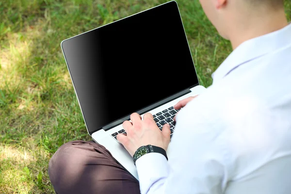 Jeune homme avec ordinateur portable à l'extérieur — Photo