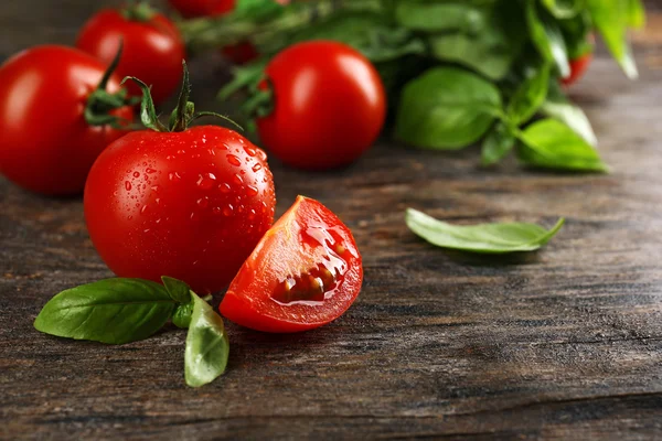 Tomates cherry con albahaca sobre mesa de madera de cerca — Foto de Stock