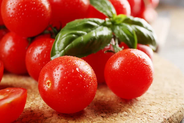 Tomates cherry con albahaca sobre mesa de madera de cerca —  Fotos de Stock