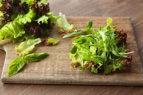 Plate of fresh mixed green salad on wooden table close up — Stock Photo, Image