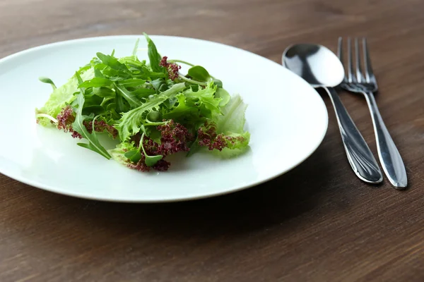 Talerz świeży zielony sałatka na drewnianym stole z bliska — Zdjęcie stockowe
