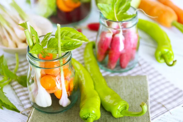 Verduras frescas en botellas de vidrio en la mesa, primer plano —  Fotos de Stock