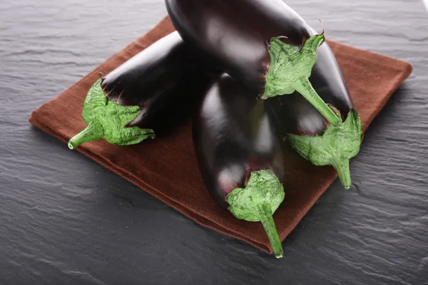 Färska aubergine på servett träbord, närbild — Stockfoto