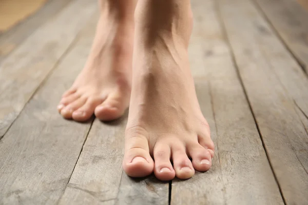 Female feet on wooden background — Stock Photo, Image