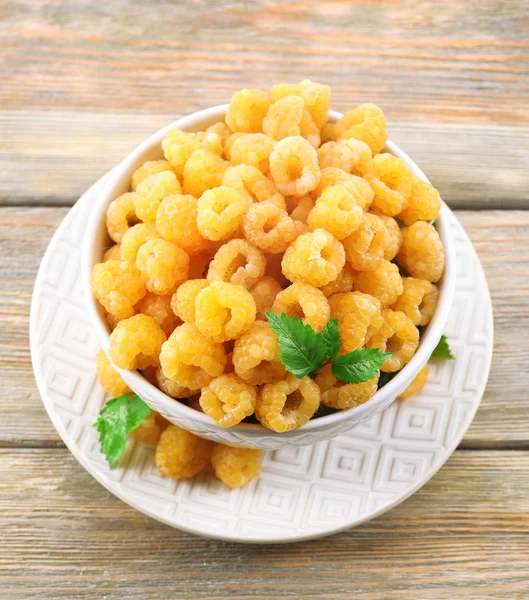 Yellow raspberries in bowl on wooden background — Stock Photo, Image