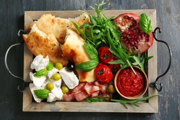 Ingredients of Mediterranean cuisine, on wooden tray, on wooden background — Stock Photo, Image