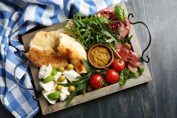 Ingrediënten van mediterrane gerechten, op houten dienblad, op houten achtergrond — Stockfoto