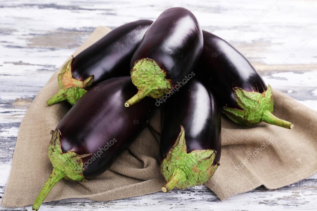 Fresh eggplant on sackcloth  wooden table, closeup