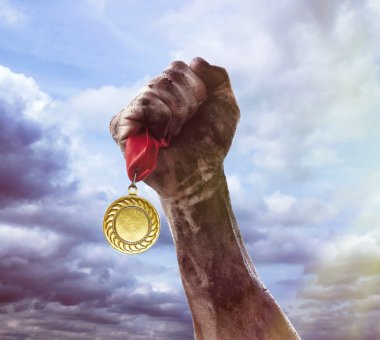 Golden medal in hand on sky background clipart