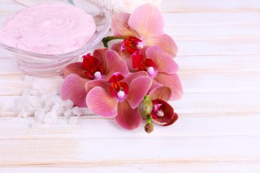 güzel çiçek ile natürmort orkide çiçek ve renk ahşap zemin üzerinde deniz tuzu ile tahta kaşıklar