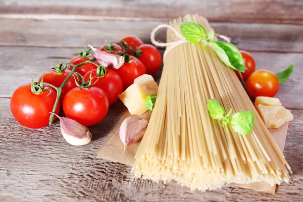 Pasta met cherry tomaten en andere ingrediënten op houten tafel achtergrond — Stockfoto