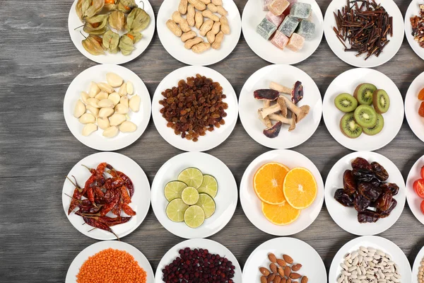 Different products on saucers on wooden table, top view — Stock Photo, Image