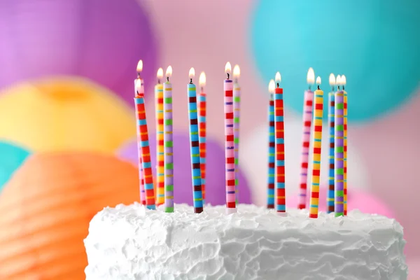 Bolo de aniversário com velas no fundo colorido — Fotografia de Stock