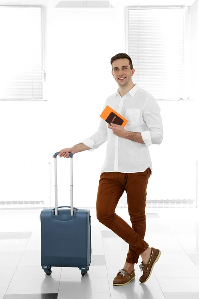 Man holding suitcase on light background — Stock Photo, Image