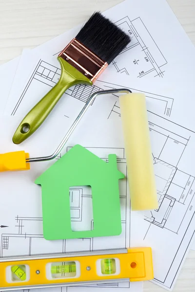 Instrumentos de construcción, plano y pinceles sobre plano de la casa sobre fondo de mesa de madera — Foto de Stock