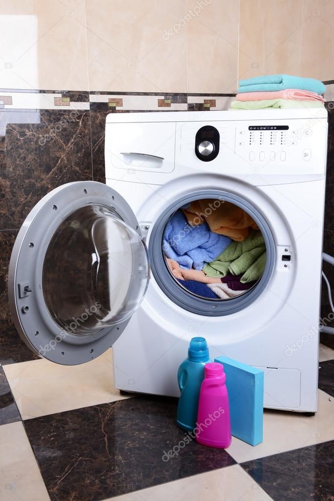 Washing machine loaded with clothes in bathroom