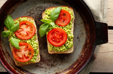 avokado ve ahşap arka plan üzerinde tava sebze vejetaryen sandviç