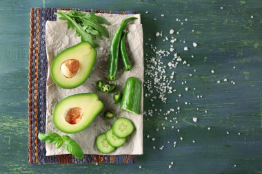 avokado, salatalık, biber ve limon kireç ahşap arka plan üzerine dilimlenmiş