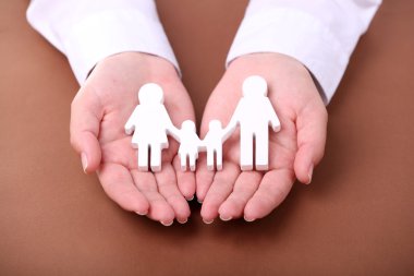 Oyuncak aile renk arka plan üzerinde tutan eller